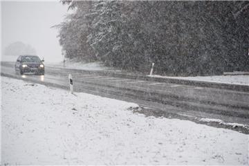 Die Bayern waren zuerst dran: Ein Auto fährt am Sonntag der Nähe von Wolfratshausen über eine verschneite Landstraße.