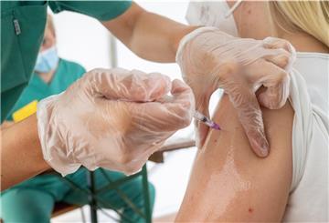 Eine junge Frau lässt sich von einer medizinischen Mitarbeiterin in einem Zelt der Gemeinde gegen das Coronavirus impfen.