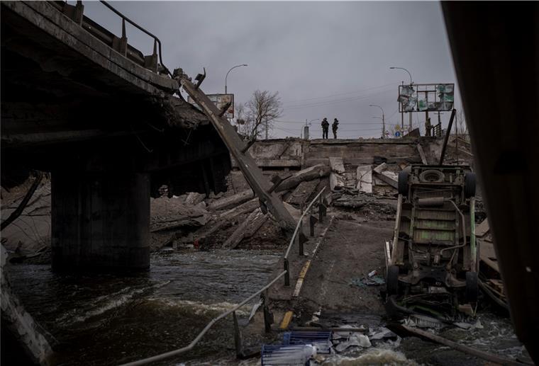 Erstmals Explosionen in Lwiw in Westukraine Ukrainische Soldaten stehen auf einer zerstörten Brücke in Irpin nordwestlich von Kiew.