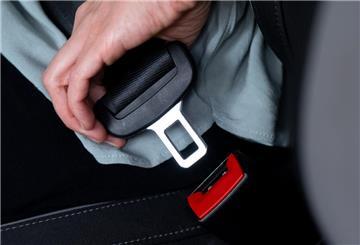 Eine Frau schnallt sich in einem Auto mit einem Sicherheitsgurt an.
