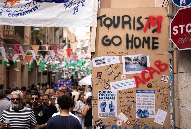 Tui-Chef will Tourismus-Proteste auf Mallorca ernst nehmen Die Botschaft an Touristen ist deutlich, auch hier bei einem Straßenfest in Barcelona.