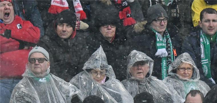 Abstiegssorgen von Werder Bremen vergrößern sich wieder Die Bremer Fans sitzen in Freiburg im Regen.