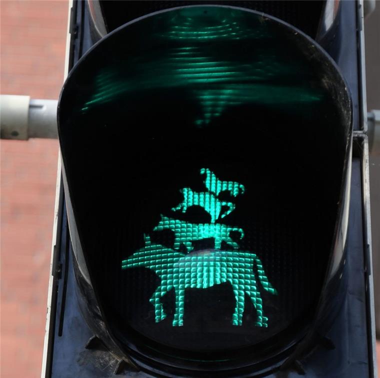 Diese 5 Besonderheiten gibt es in Bremen zum Freimarkt Die Bremer Stadtmusikanten leuchten als Grün-Anzeige an einer Ampel, die an einem Übergang zum Freimarkt steht.