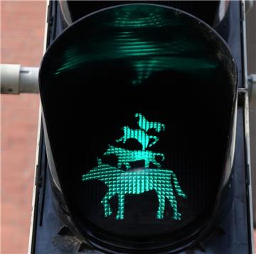 Die Bremer Stadtmusikanten leuchten als Grün-Anzeige an einer Ampel, die an einem Übergang zum Freimarkt steht.
