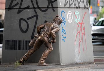 Die Bronzestatue stellt einen Mann mit Kapuzenpulli dar, der eine Spraydose in der Hand hält.