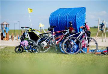 Die Fahrräder einer Familie lehnen an einem Strandkorb.