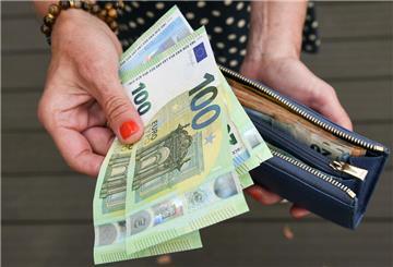 Eine Frau hält eine mit mehreren Geldscheinen in die Kamera. Aus dem Klimageld in Höhe von bis zu 300 Euro pro Person wird nun wohl doch nichts. 