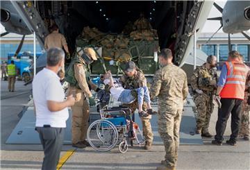 Während der militärischen Evakuierungsoperation von Schutzbedürftigen aus der afghanischen Hauptstadt Kabul tragen deutsche Bundeswehrsoldaten einen Afghanen aus dem Laderaum eines Airbus A400M und setzen ihn in einen Rollstuhl.