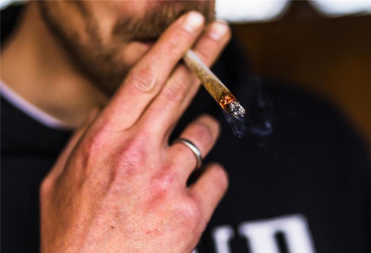ARCHIV - 17.04.2023, Baden-Württemberg, Heitersheim: ILLUSTRATION - Ein Cannabis-Patient zieht an einem Joint. Foto: Philipp von Ditfurth/dpa +++ dpa-Bildfunk +++