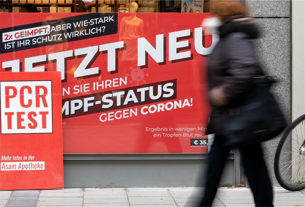Höchststand: RKI registriert 52.826 Corona-Neuinfektionen Ein Schild mit der Aufschrift "Jetzt Neu - Testen Sie ihren Impf-Status gegen Corona" ist in der Innenstadt von München im Schaufenster von einer Apotheke zu sehen