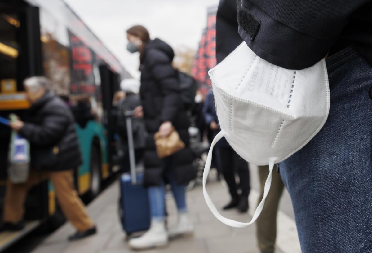 Ein Mann wartet mit einer Maske am Handgelenk auf einen Bus am Stuttgarter Hauptbahnhof.