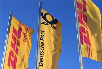 Fahnen des Logistikkonzerns DHL und seiner Brieftochter Deutsche Post (M) wehen vor der Konzernzentrale an Masten. (zu dpa: «Deutsche Post streicht 8.000 Stellen»)
