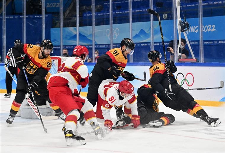 Nur 3:2 - DEB-Team quält sich zum Sieg gegen China Olympia, Eishockey, Vorrunde, Gruppe A, Deutschland - China, im Nationalen Hallenstadion, Die Spieler aus Deutschland und China kämpfen um den Puck.