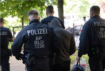 Polizisten führen bei einer Razzia gegen Schleuser eine Person ab