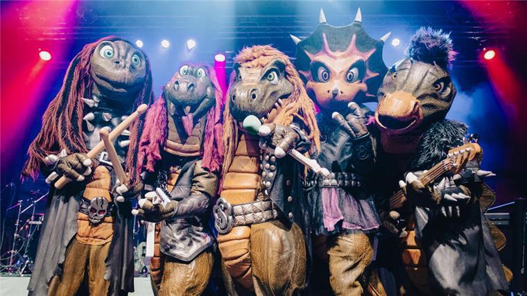 Was am Wochenende in Bremerhaven und dem Cuxland vom 25.–27. April los ist Fünf Musiker in Dino-Kostümen stehen auf einer Bühne. Es ist die Band Heavysaurus, die für einen Auftritt nach Bremerhaven kommt.