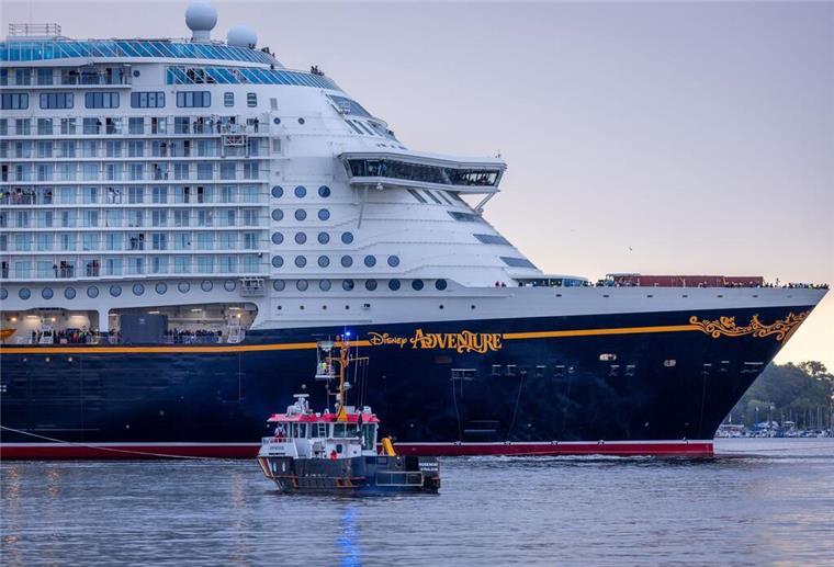 Das in der Wismarer Werft gebaute Kreuzfahrtschiff «Disney Adventure» wird von mehreren Schleppern aus dem Hafen Richtung Wismarbucht und Ostsee gezogen.