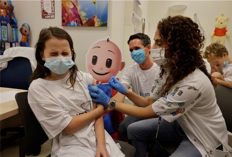 Corona: Israel impft Kinder ab fünf Jahren Die elfjährige Noa Bershadsky (l) reagiert, als sie von einer medizinischen Angestellten im Clalit-Gesundheitsdienst eine Dosis eines des Corona-Impfstoffes erhält.