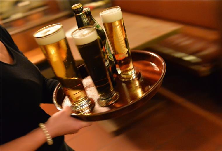 Höhere Löhne für niedersächsisches Hotel- und Gaststättenpersonal Eine Bedienung trägt in einem Lokal ein Tablett mit Bier.