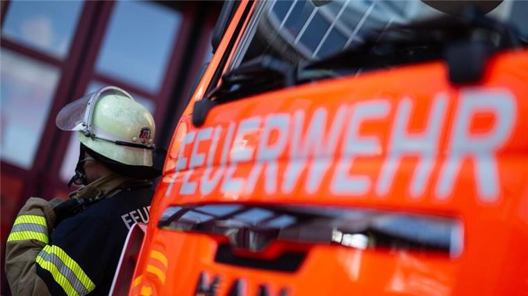 Brand von Dachstuhl verursacht 300.000 Euro Schaden Eine Einsatzkraft der Feuerwehr steht neben einem Einsatzfahrzeug der Feuerwehr.