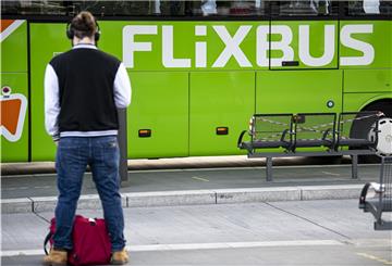 Mann steht vor einem grünen Flixbus.