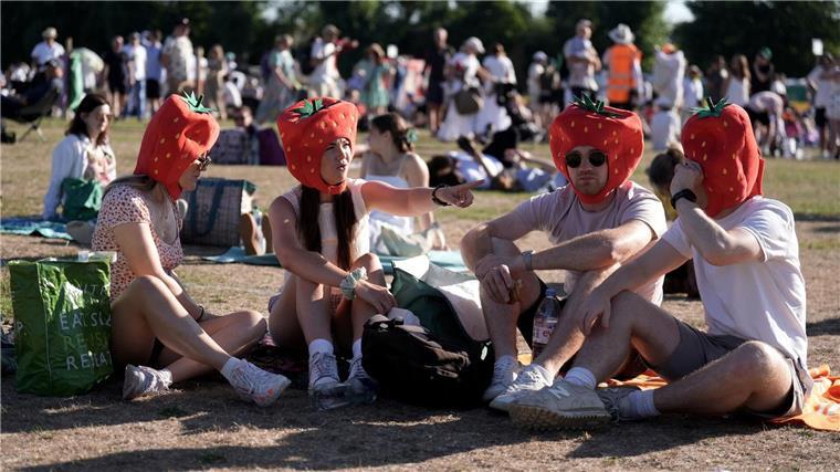 Rote Früchte auf Köpfen und in Schälchen Die Fans stehen beim berühmten Tennisturnier Wimbledon sehr auf Erdbeeren.