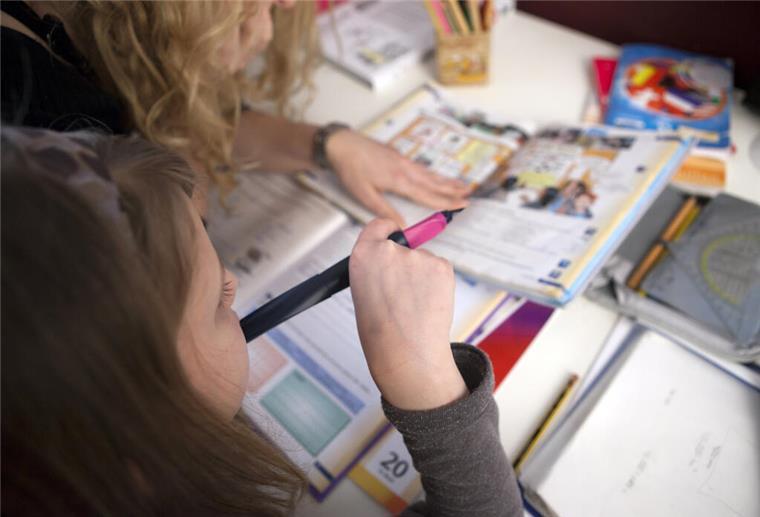 Bremen: Keine Rückkehr zu Schulnoten ab der dritten Klasse Kind sitzt über einem Schulheft
