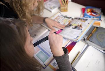 Kind sitzt über einem Schulheft