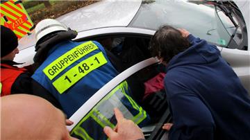 Die Feuerwehr muss einer in einem Auto eingeklemmten Frau helfen.