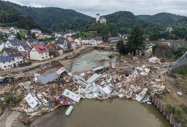 Extremwetter: 18.000 Tote und 127 Milliarden Euro Schaden in Deutschland Trümmer in einem Fluss vor einer Siedlung