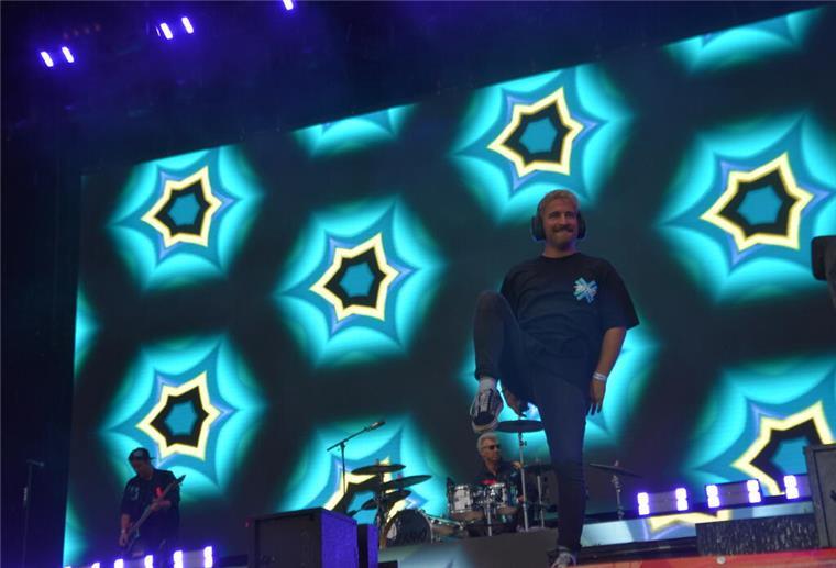 Regen verdunstet in den Deichbrandflammen Mann auf Bühne mit Kaleidoskopoptik