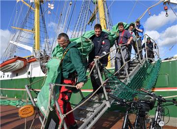 Die frei willigen Helfer bringen die Segel von Bord der "Alexander von Humboldt II". Das Schiff bekommt einen neuen Satz grüner Segel. Der erste wird bis zum nächsten Tausch überholt.