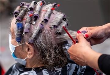 Einer Kundin werden in einem Friseursalon die Haare frisiert.