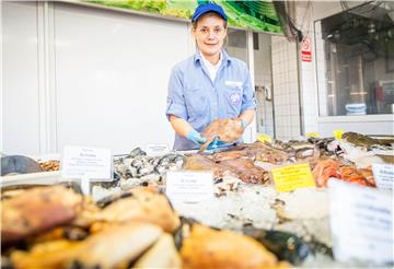 Die gebürtige Portugiesin Tina Rebelo ist Fischverkäuferin mit Leidenschaft bei Schüttler & Seifert im Fischereihafen, sie zeigt eine der bei Kunden beliebte, eisgekühlte Rotzunge. Foto: Hartmann