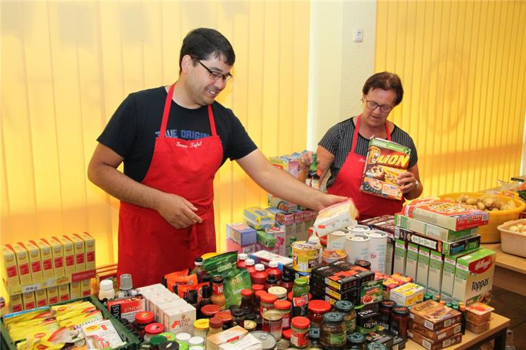 Zucker, Salz und Mehl fehlen: Zevener Tafel hat erste Spenden erhalten Die gespendeten Lebensmittel müssen von den ehrenamtlichen Mitarbeitern der Tafel sortiert und zur Verteilung auf die Regale und Tische gelegt werden. Hier sind Davod Arian und Ingrid Nieswandt (die Leiterin der Tafel) am Werk.