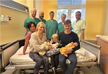 Die glückliche Familie mit ihren Drillingen, umgeben vom engagierten Team der Geburtshilfe, Kinderklinik und der Kinderintensivstation.