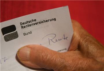 Eine ältere Frau hält ihren Rentenbescheid in der Hand.