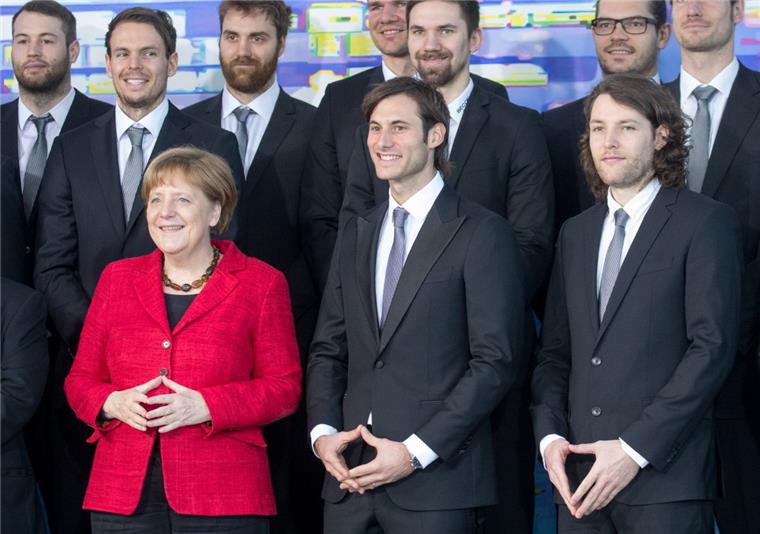 Die Merkelraute erobert die Welt Die Handballer Uwe Gensheimer (Mitte) und Johannes Sellin (rechts) haben sich beim Fototermin mit Angela Merkel einen kleinen Spaß erlaubt.