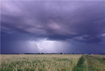  Dunkle Gewitterwolken und Blitz über Feld