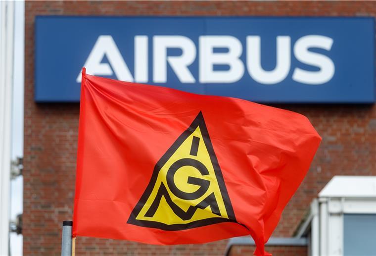Kommt es zu einem Streik bei Airbus? Eine Fahne der IG-Metall weht bei einem Warnstreik vor dem Schriftzug "Airbus" an dem Werk in Hamburg-Finkenwerder.