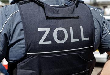 Ein Beamter trägt während seines Dienstes eine Schutzweste mit der Rückenaufschrift "Zoll".