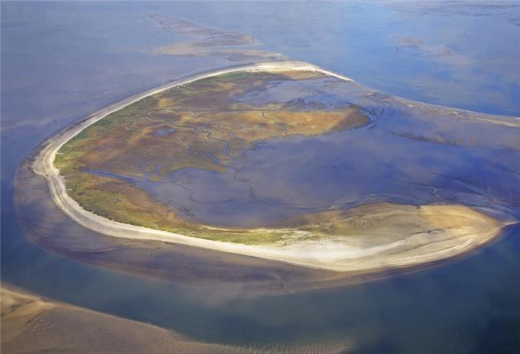 Unglaublich! Diese beliebte Nordseeinsel läuft langsam Richtung Festland Luftfoto einer Insel. Die Insel Trischen wandert jährlich rund 30 Meter ostwärts durch das Wattenmeer. Ihre ständige Veränderung zeigt, wie dynamisch die Natur an der Nordseeküste wirklich ist.