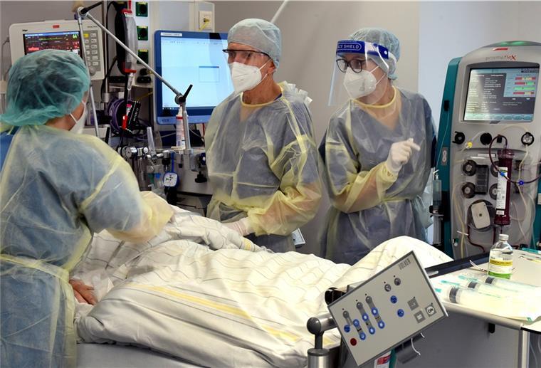 Intensivstationen unter Druck: Hunderte Betten aus Notfallreserve Auf der Corona-Intensivstation vom Evangelischen Krankenhaus Paul Gerhard Stift stehen die Oberärztin Agnieszka Töpper (l), Chefarzt Franz X. Kleber und Schwester Jane am Bett eines Patienten. Das Krankenhaus in Wittenberg hat seine sonst 10 Intensivplätze auf 16 aufgestockt, die gegenwärtig auch alle belegt sind.
