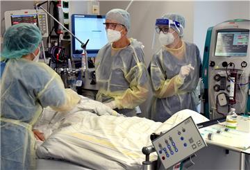 Auf der Corona-Intensivstation vom Evangelischen Krankenhaus Paul Gerhard Stift stehen die Oberärztin Agnieszka Töpper (l), Chefarzt Franz X. Kleber und Schwester Jane am Bett eines Patienten. Das Krankenhaus in Wittenberg hat seine sonst 10 Intensivplätze auf 16 aufgestockt, die gegenwärtig auch alle belegt sind.