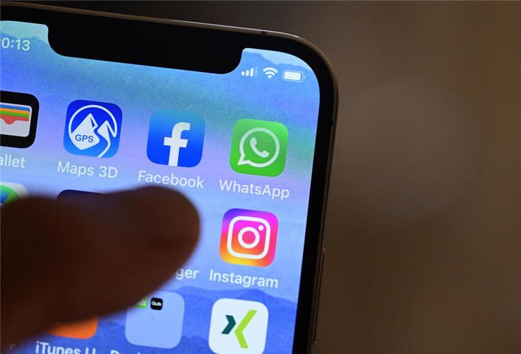 EU will Regeln für Facebook, Twitter und weitere Internetriesen verschärfen Eine Hand hält ein iPhone, auf dem Sozial Media Apps dargestellt sind
