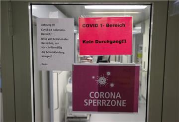 Tür einer Intensivstation mit Corona-Warnschildern 