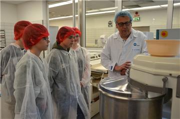 Die Knetmaschine im Milk Innovation Center (MIC) in Zeven läuft auf Hochtouren: Gemeinsam mit Ernst-Georg Toenjes, Applikationsmanager beim DMK, stellen die Schüler des MINT-Projektes Croissants her. Diese dürfen sie später verspeisen.