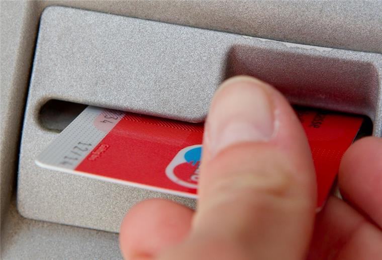 Wespa schließt SB-Standort und gibt zwei Geldautomaten auf Ein Kunde schiebt seine Karte in einen Geldautomaten.