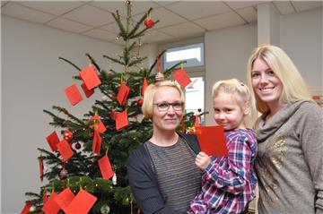 Die KZW-Mitarbeiterinnen Nadine Kuhlmann (links mit Tochter Marje) und Dana Kuhr freuen sich auf Besucherinnen und Besucher  in der Geschäftsstelle der Kreiszeitung Wesermarsch in Nordenham, die einen Kinderwunsch erfüllen möchten.