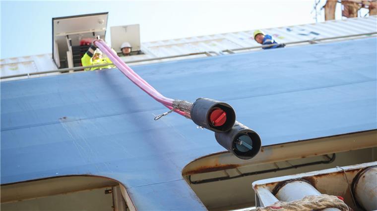 Bislang nutzen wenige Containerschiffe Landstrom Die Landstromkabel eines Containerschiffs im Hamburger Hafen werden weitergereicht. (Symbolbild)