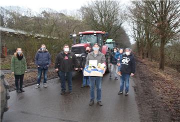 Die Landwirte rund um Volker Peters (vorne) und Horst Meyer von „Land schafft Verbindung“ haben dem Aldi-Logistikleiter Klaus-Uwe Riesel zum Abschied einen Präsentkorb übergeben.
